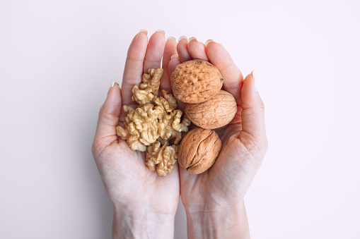 Close up of woman hands holding walnuts. The view from the top. High quality photo