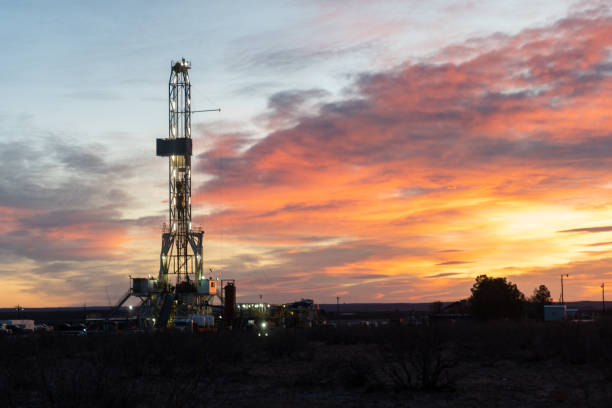 una plataforma de fracking de perforación de petróleo o gas mientras sale el sol en nuevo méxico - oil industry industry new mexico oil drill fotografías e imágenes de stock