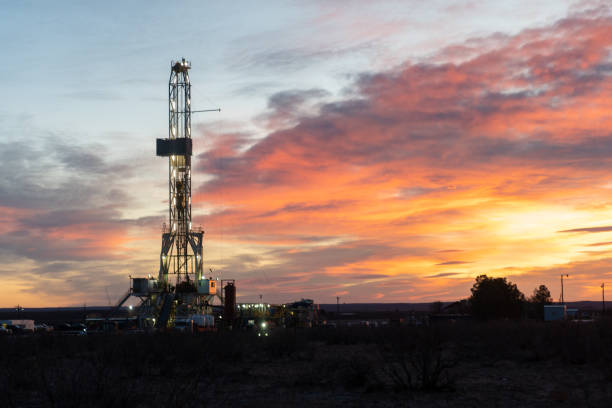 an oil or gas drill fracking rig pad as the sun rises in new mexico - oil industry industry new mexico oil drill imagens e fotografias de stock