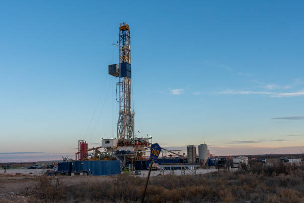 an oil or gas drill fracking rig pad as the sun rises in new mexico - oil industry industry new mexico oil drill imagens e fotografias de stock