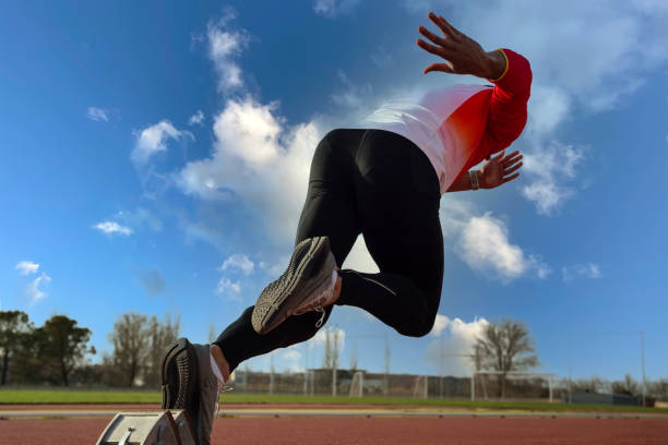 A young sprinter leaves the starting block at the athletics track.