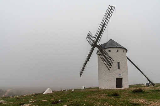 A view of a windmills of Campo de Criptana in La Mancha on a very foggy morning