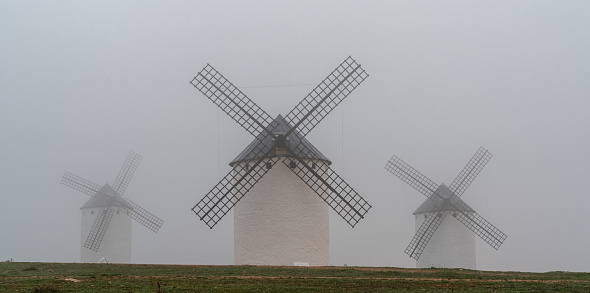 A view of the windmills of Campo de Criptana in La Mancha on a very foggy morning