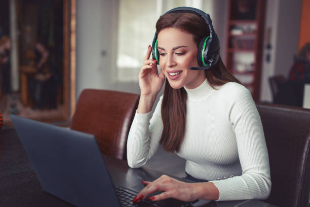 istock Young positive woman with headset talking online 1306017285