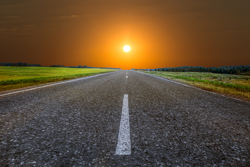 Sunrise on the horizon over an empty country highway