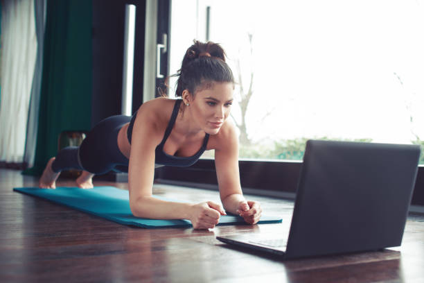 istock Young fitness trainer showing plank exercise online 1306021158