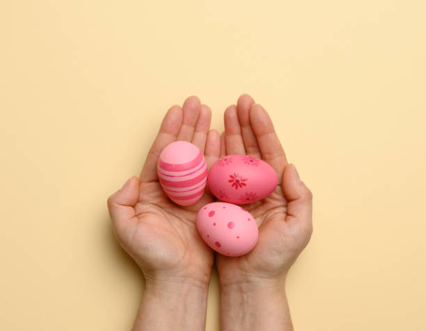 istock female hand holding multicolored decorative easter eggs on a beige background 1306021559