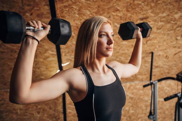 istock Woman training with dumbbells in gym 1306022289