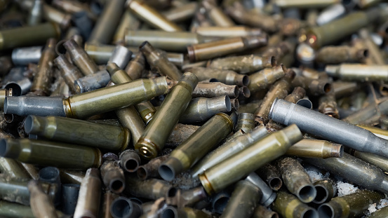Empty carbine or rifle cartridges. A large number of cases. Background of brass ammunition cartridges to illustrate armed conflict, war or shooting