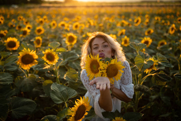 istock Playful woman in sunflower field 1306026323