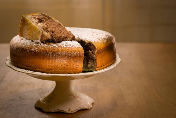 istock Marble cake on old base and wooden table with a cut piece 1306027644