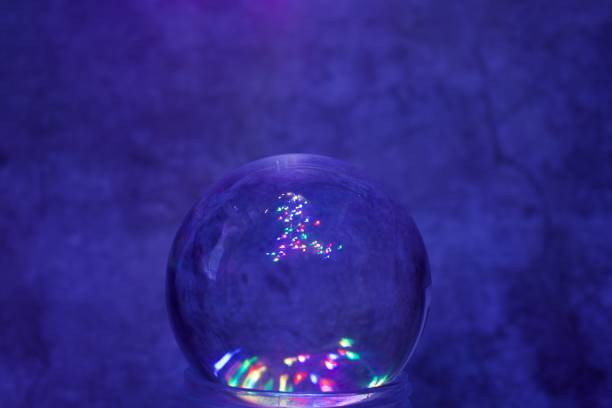 istock Neon color light trails reflected in crystal, lens ball with blue background. 1306028410
