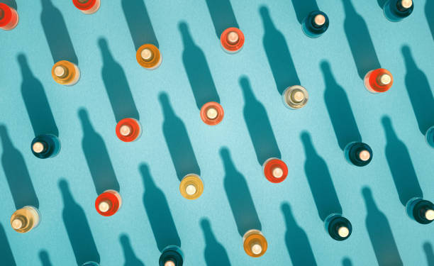 вид сверху на стеклянные бутылки с металлическими колпачками, стоящими на бирюзово-голубом фоне. - parks brewery стоковые фото и изображения