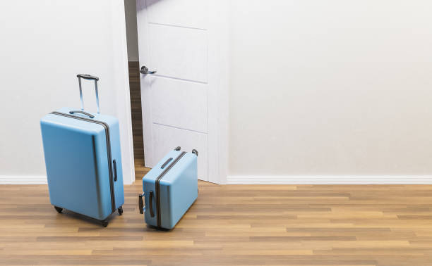 istock blue suitcases in front of an open door 1306035885