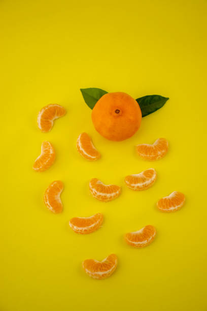 istock Tangerine with leaves isolated on yellow background 1306036763