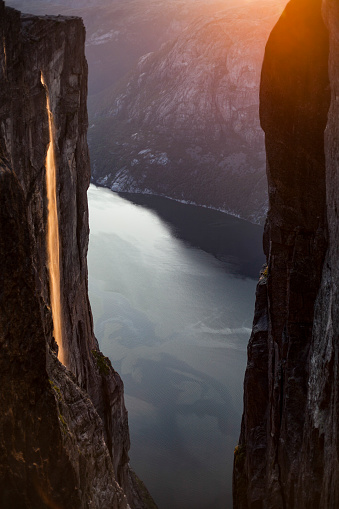 View on Lysefjorden and waterfall from Kjeragbolten at sunset.