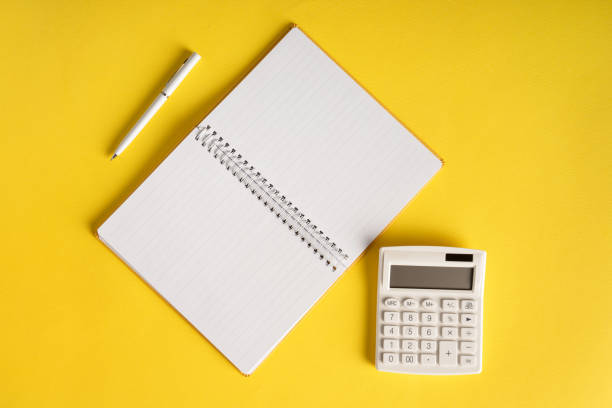 istock Office book with a pencil and a calculator on a yellow background 1306042506
