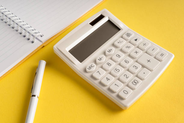 istock Office notebook with a pencil and a calculator on a yellow background 1306042509