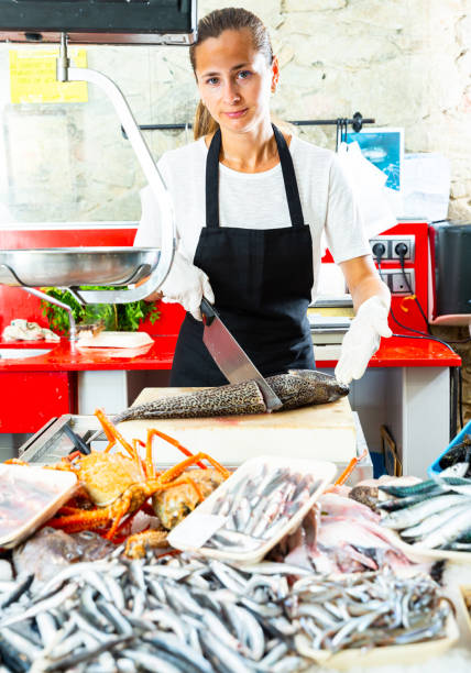istock Saleswoman processing fish for sale 1306043176