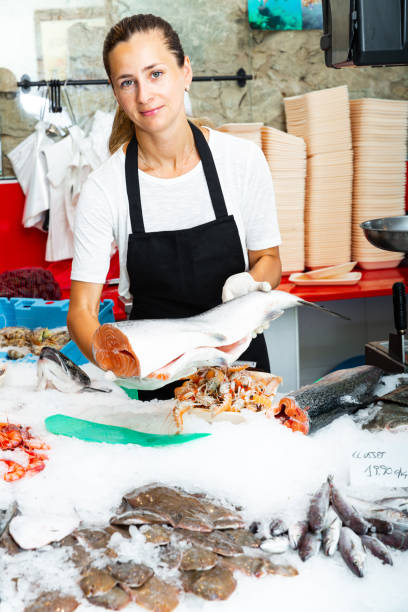 istock Polite female worker offering fresh raw salmon 1306043177
