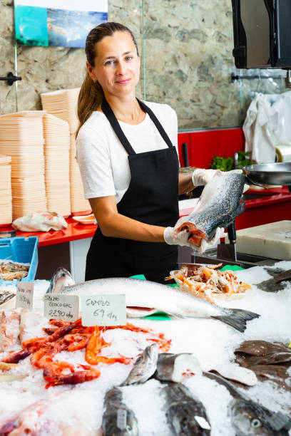 istock Casual female worker offering fresh raw salmon 1306043185