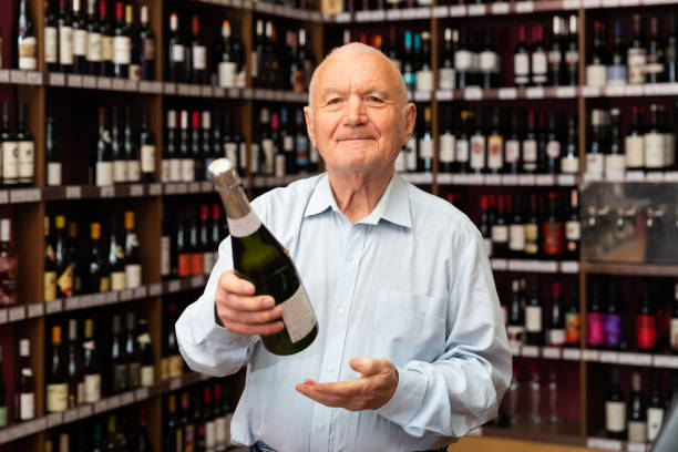 istock Attentive elderly man chooses champagne in a liquor store 1306043237