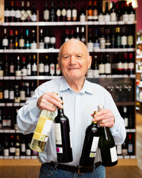 istock Joyful elderly man with bottles of wine 1306043238