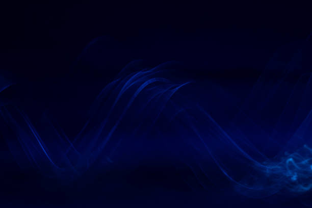 istock Abstract trailing blurred motion metallic blue ribbon wave with black background 1306046368
