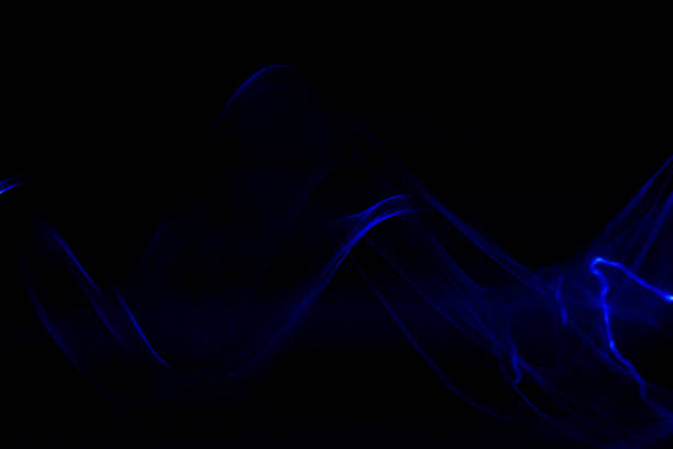 istock Abstract trailing blurred motion metallic blue ribbon wave with black background 1306046370