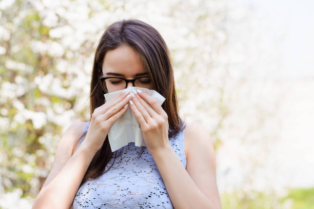 istock Sick young girl against blooming trees in spring 1306046682