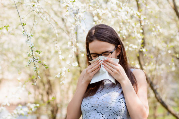istock Young student girl hiding her face with white light handkerchief while sneezing 1306046684