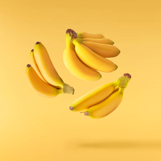 Fresh ripe baby bananas falling in the air stock photo