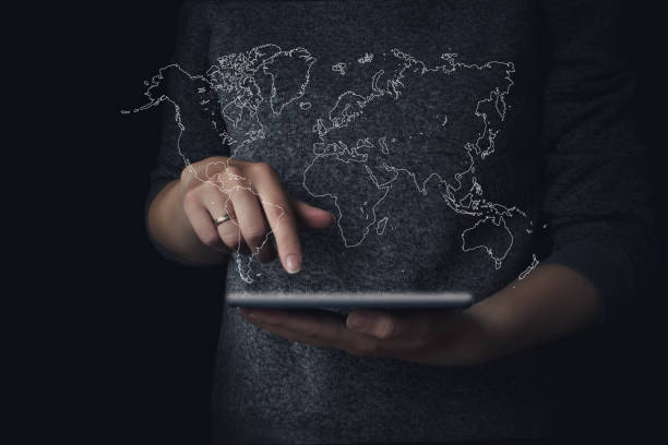 istock Female teen hands using tablet with hologram world map. 1306047522