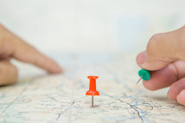 istock Selective focus of Red pin and blurred hand holding a pin on map background 1306052866