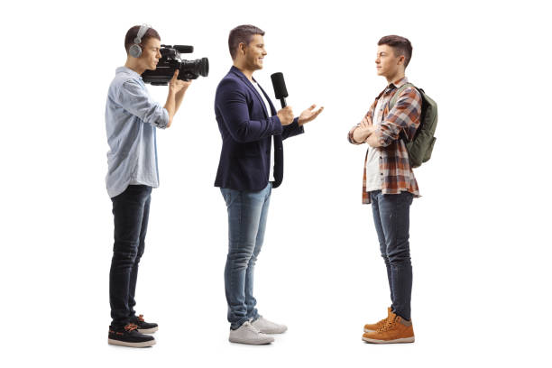 Reporter with a microphone and a cameraman interviewing a male student