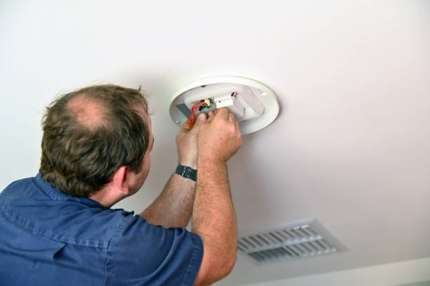 istock Electrician installing new  ceiling light fixture 1306059755