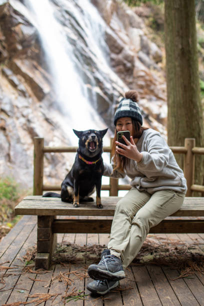 istock Woman taking a selfie with her dog and waterfall behind 1306061345