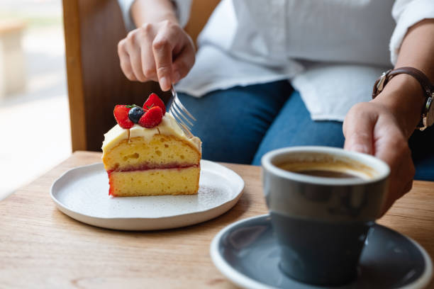 istock a woman eating cake and drinking coffee in cafe 1306061424