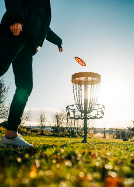 donna che snoccia un disco nel gol del canestro - golf putting determination focus foto e immagini stock