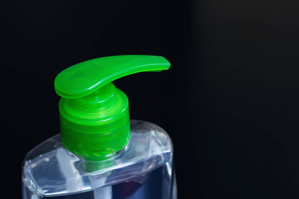 istock Green liquid soap dispenser black background close up 1306069540