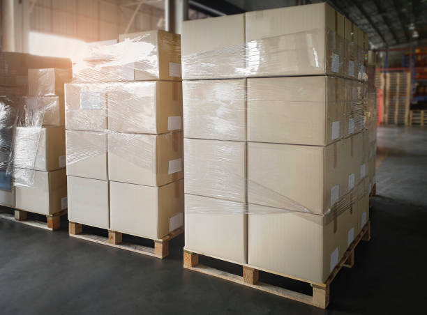 istock Stacked of Cardboard Boxes Wrapped Plastic on Pallet Rack. Interior of Storage Warehouse. Shipping Warehouse Logistics. Industry Cargo Export- Import. 1306069636