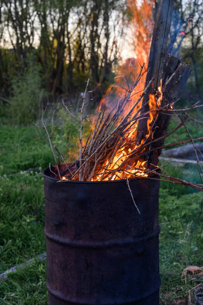 istock garbage incineration in rusty metal barrel. burning branches and old grass from the land plot in a barrel. spring cleaning of the backyard and garden. a safe alternative to spring grass burn 1306072482