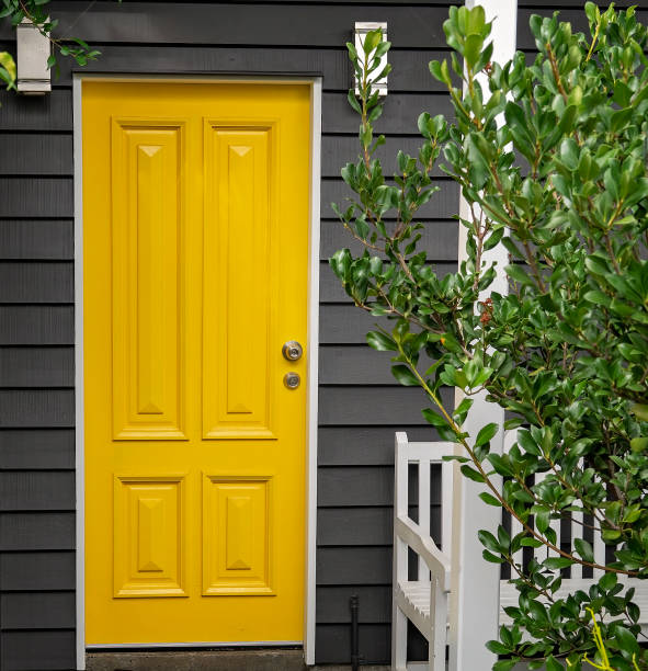 Yellow Door A bright yellow front entrance door in a renovated old Queensland home front door stock pictures, royalty-free photos & images