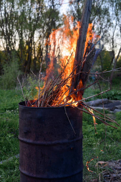 istock garbage incineration in rusty metal barrel. burning branches and old grass from the land plot in a barrel. spring cleaning of the backyard and garden. a safe alternative to spring grass burn 1306072510