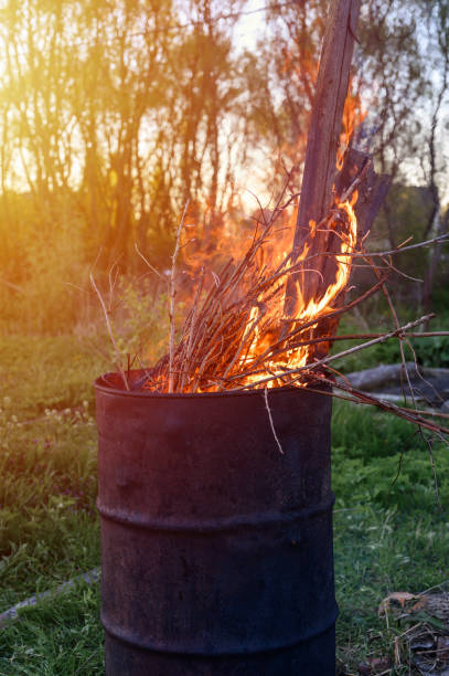 istock garbage incineration in rusty metal barrel. burning branches and old grass from the land plot. spring cleaning of the backyard and garden. a safe alternative to spring grass burn. flare 1306072550