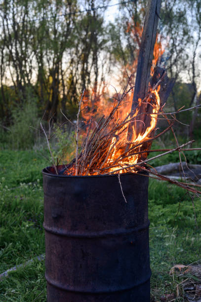 istock garbage incineration in rusty metal barrel. burning branches and old grass from the land plot in a barrel. spring cleaning of the backyard and garden. a safe alternative to spring grass burn 1306072618
