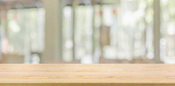 istock Empty wood table top with cafe restaurant window blur background 1306074893