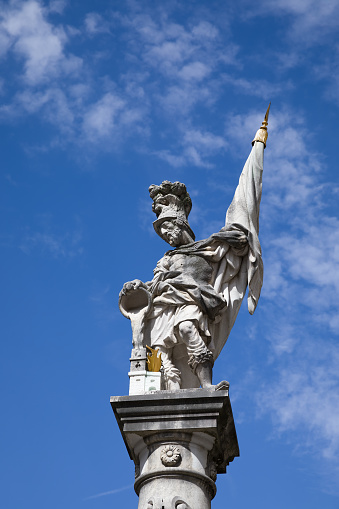 The statue of Saint Florian against a blue sky on the Old Market Square (Alter Markt) in the Historic Centre of the City of Salzburg, Austria.