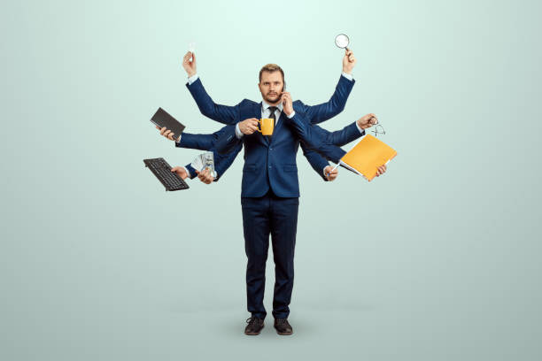 Businessman with many hands in a suit. Works simultaneously with several objects, a mug, a magnifying glass, papers, a contract, a telephone. Multitasking, efficient business worker concept. Businessman with many hands in a suit. Works simultaneously with several objects, a mug, a magnifying glass, papers, a contract, a telephone. Multitasking, efficient business worker concept multitasking stock pictures, royalty-free photos & images