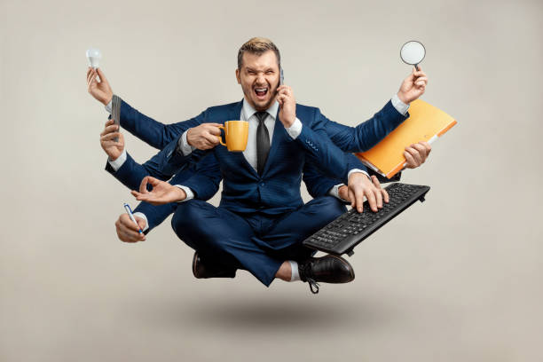istock Businessman with many hands in a suit. Works simultaneously with several objects, a mug, a magnifying glass, papers, a contract, a telephone. Multitasking, efficient business worker concept. 1306079940
